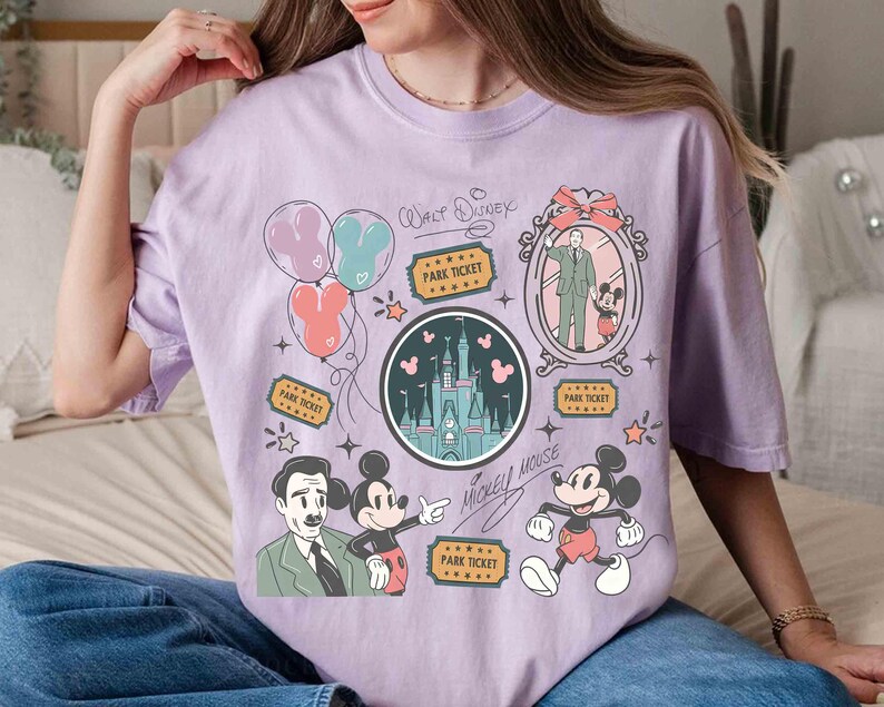 Peut inclure: Un t-shirt lilas avec un motif de dessin anim&eacute; repr&eacute;sentant Mickey Mouse, Walt Disney et un ch&acirc;teau. Le t-shirt comprend des illustrations de ballons, de billets de parc et d'&eacute;toiles. Les mots "Walt Disney" et "Mickey Mouse" sont &eacute;galement imprim&eacute;s.