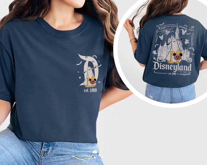 May include: Navy blue t-shirt with a Disneyland Halloween design. The front has a stylized "D" with a ghost and pumpkin. The back shows a castle, ghost, and pumpkins with the text "Disneyland est. 1955."