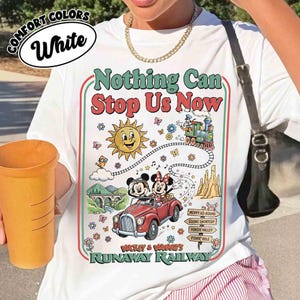 Peut inclure: T-shirt blanc avec un graphisme color&eacute; repr&eacute;sentant Mickey et Minnie Mouse dans une voiture rouge, un soleil souriant et le texte "Nothing Can Stop Us Now". Le t-shirt porte &eacute;galement le texte "Runaway Railway".