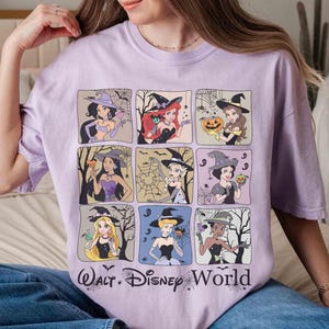 May include: A lilac t-shirt with a grid of nine cartoon princesses dressed as witches. Each princess is in a square frame with Halloween-themed backgrounds. The words "Walt Disney World" are printed in a stylized font at the bottom.