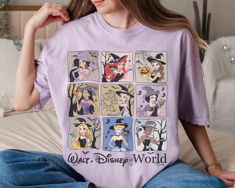 May include: A lilac t-shirt with a grid of nine cartoon princesses dressed as witches. Each princess is in a square frame with Halloween-themed backgrounds. The words "Walt Disney World" are printed in a stylized font at the bottom.