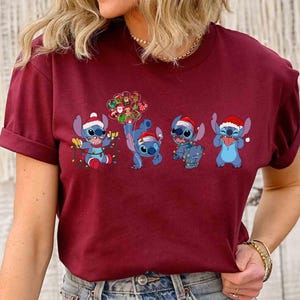 Puede incluir: Camiseta burdeos con un dise&ntilde;o festivo del personaje Stitch de Lilo & Stitch. Los extraterrestres azules llevan gorros de Pap&aacute; Noel y est&aacute;n decorados con luces y adornos navide&ntilde;os. Una divertida camiseta gr&aacute;fica con tem&aacute;tica navide&ntilde;a.