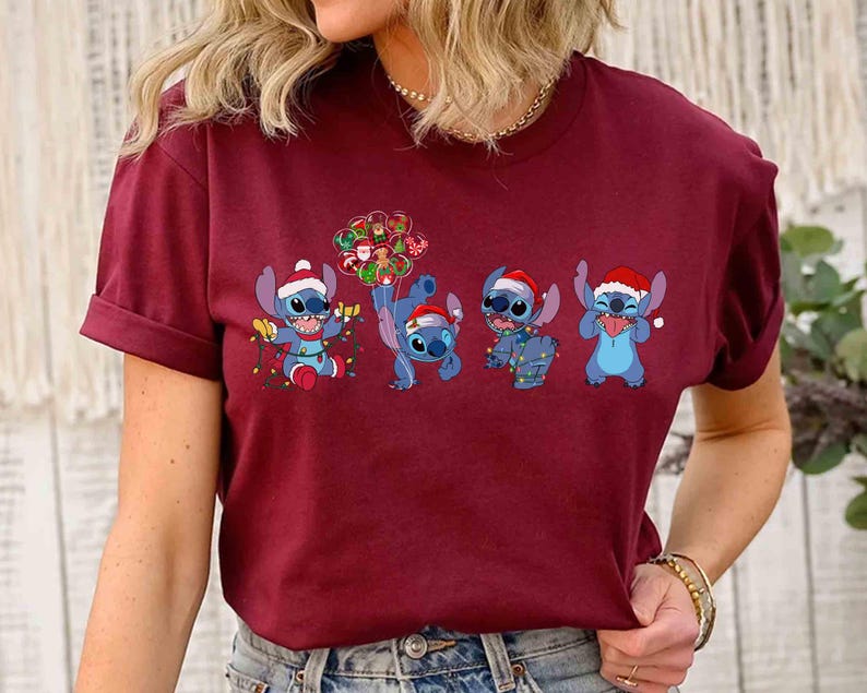 Puede incluir: Camiseta burdeos con un dise&ntilde;o festivo del personaje Stitch de Lilo & Stitch. Los extraterrestres azules llevan gorros de Pap&aacute; Noel y est&aacute;n decorados con luces y adornos navide&ntilde;os. Una divertida camiseta gr&aacute;fica con tem&aacute;tica navide&ntilde;a.