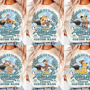 May include: Cream-colored long-sleeve shirts featuring Disney characters in an Alaska-themed design. Each shirt has a circular graphic with the text "Disney Wonder Alaska Cruise Custom Name". The graphics include cartoon characters, mountains, and penguins.