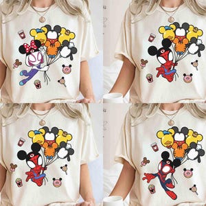 Puede incluir: Camisetas color crema con gr&aacute;ficos de dibujos animados coloridos. Los dise&ntilde;os presentan personajes como Spider-Man y Minnie Mouse sosteniendo globos con forma de Mickey Mouse. Otros gr&aacute;ficos incluyen donas, helados y tazas de caf&eacute;.