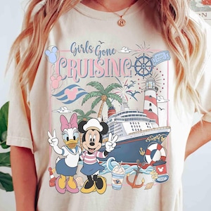 Peut inclure: T-shirt cr&egrave;me avec un graphisme color&eacute; de Daisy Duck et Minnie Mouse sur un bateau de croisi&egrave;re. Le motif comprend les mots "Girls Gone Cruising", un phare et des &eacute;l&eacute;ments nautiques.