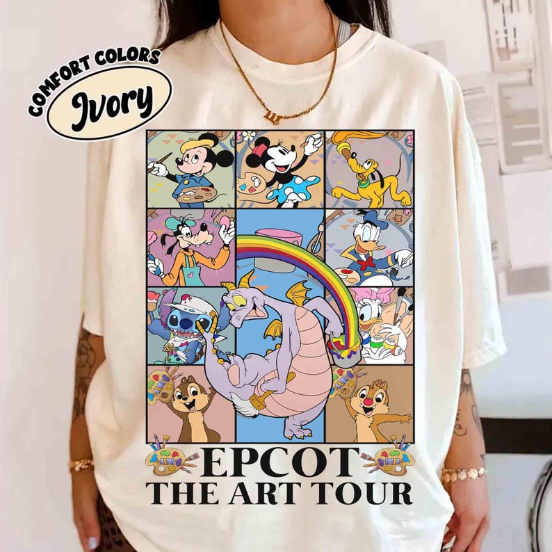 May include: Ivory-colored t-shirt featuring a colorful graphic of Disney characters in a grid, including Mickey Mouse, Minnie Mouse, Pluto, Goofy, Donald Duck, Stitch, Chip and Dale, and Figment. The text "EPCOT THE ART TOUR" is printed below the grid.