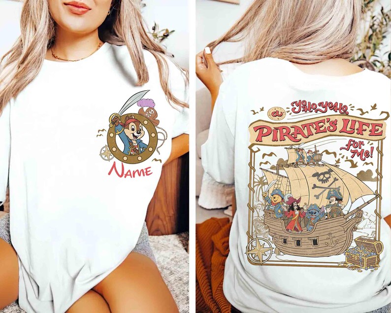 K&ouml;nnte beinhalten: Wei&szlig;es T-Shirt mit Piratenmotiv. Auf der Vorderseite befindet sich eine Cartoonfigur in einem Bullauge mit dem Wort "Name" darunter. Auf der R&uuml;ckseite ist ein Piratenschiff mit Figuren und dem Text "A Pirate's Life For Me!" abgebildet.