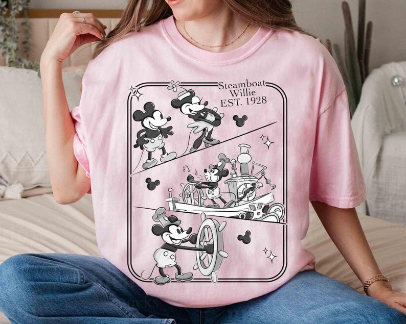 Może przedstawiać: Jasnor&oacute;żowa koszulka z czarno-białą grafiką Myszki Miki z Steamboat Willie, EST. 1928. Grafika przedstawia Myszkę Miki w r&oacute;żnych scenach. Koszulka ma okrągły dekolt i kr&oacute;tkie rękawy.