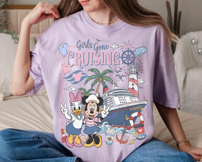 Peut inclure: T-shirt lilas clair avec l'inscription "Girls Gone Cruising" et un motif avec Daisy Duck et Minnie Mouse. Le motif comprend un bateau de croisi&egrave;re, un phare, des palmiers et des &eacute;l&eacute;ments nautiques. Le t-shirt est de coupe ample.