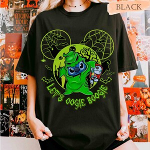 May include: Black t-shirt featuring a green graphic of Stitch dressed as Oogie Boogie, with the text "Let's Oogie Boogie." The design includes Mickey Mouse ears, spiderwebs, and bats, perfect for Halloween. The word "BLACK" is printed at the top.