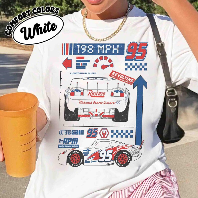 K&ouml;nnte beinhalten: Ein wei&szlig;es T-Shirt mit einem Grafikdruck eines Rennwagens und dem Text Lightning McQueen, Rust-eze, 198 MPH, 95, Octane Gain und RPM. Das Design zeigt eine R&uuml;ckansicht, eine Seitenansicht eines Rennwagens, einen Tacho und Karomuster.