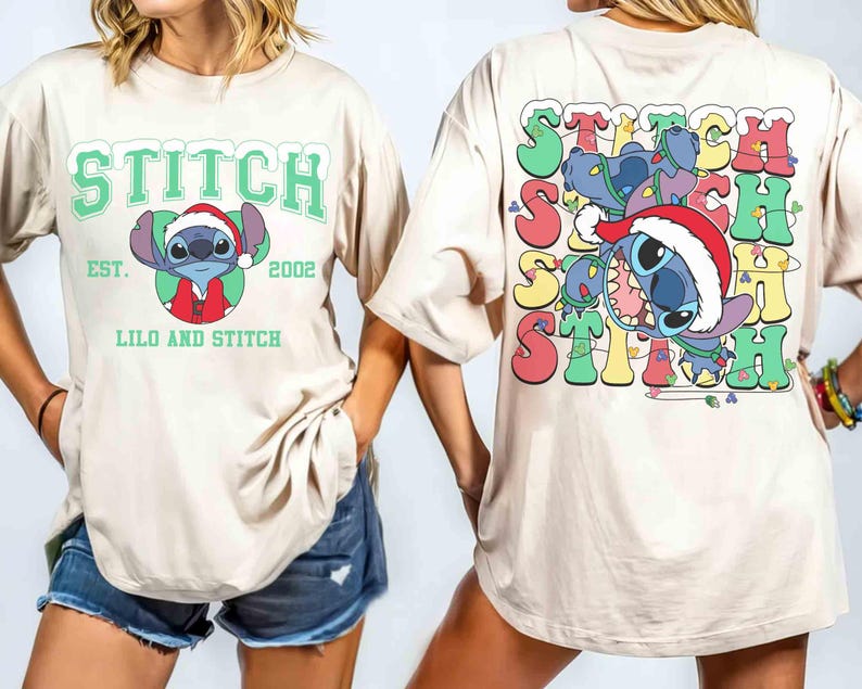 May include: Beige t-shirt featuring a graphic of Stitch wearing a Santa hat, with the text "STITCH" above and "LILO AND STITCH" below. The back of the shirt has a colorful Stitch design with the word "STITCH" repeated.