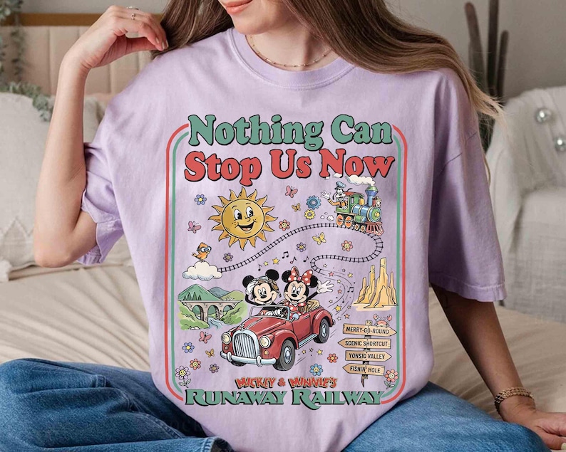 Peut inclure: T-shirt lilas avec un motif color&eacute; repr&eacute;sentant Mickey et Minnie Mouse dans une voiture rouge, un train et un soleil souriant. Le texte "Nothing Can Stop Us Now" et "Runaway Railway" est &eacute;galement affich&eacute;.