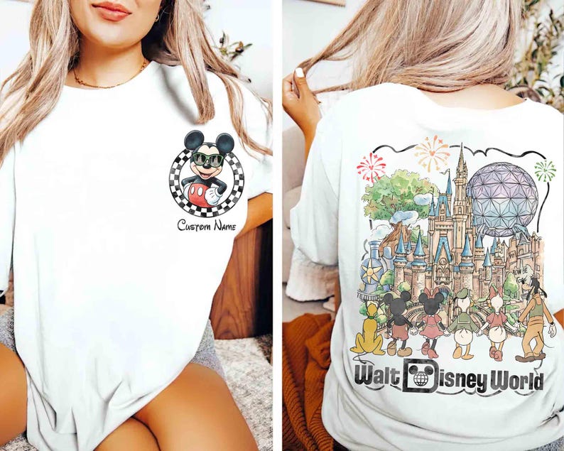 May include: White t-shirt featuring Mickey Mouse wearing sunglasses, a red shorts, and a black and white checkered circle. The back of the shirt displays a colorful illustration of Walt Disney World with characters and fireworks.