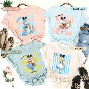 May include: Four short-sleeve t-shirts in heather peach, light blue, heather ice blue, and natural colors. Each shirt features a graphic of a character wearing Mickey Mouse ears, including The Caterpillar, White Rabbit, Tweedledee, and Alice.