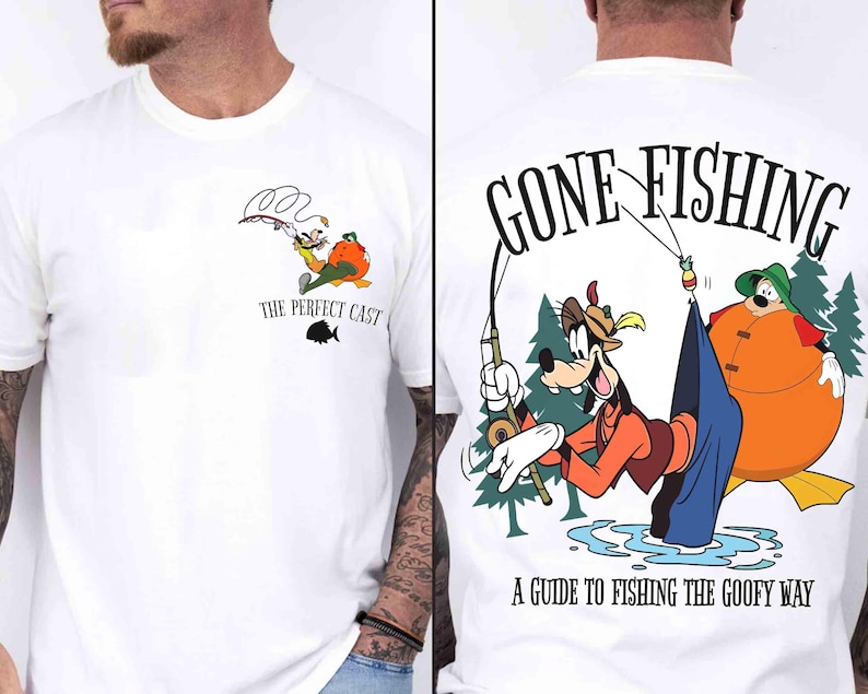 May include: White t-shirt featuring a cartoon illustration of Goofy fishing. The front of the shirt has a small graphic with the text "THE PERFECT CAST". The back of the shirt has a larger graphic with the text "GONE FISHING" and "A GUIDE TO FISHING THE GOOFY WAY".