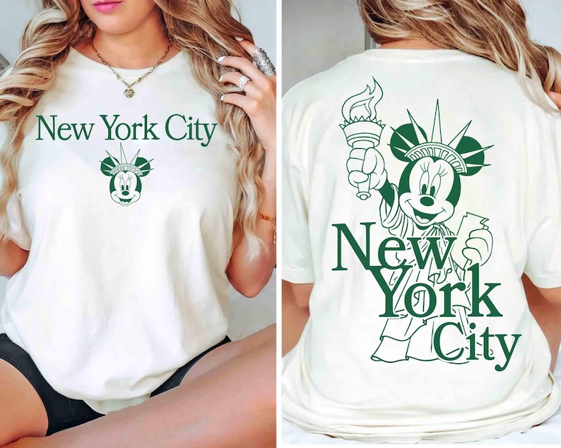 May include: Off-white t-shirt with a green graphic of Minnie Mouse as the Statue of Liberty, holding a torch. The text "New York City" is above and below the graphic. The front of the shirt has the text "New York City" and a Minnie Mouse graphic.