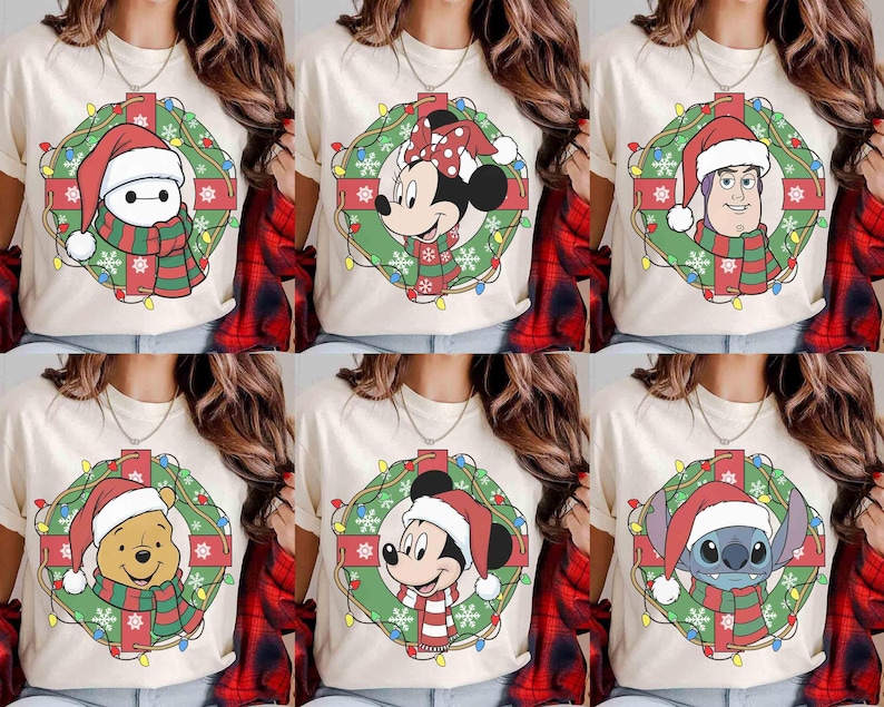 Op de afbeelding: Cr&egrave;mekleurige T-shirts met kerstthema Disney-personageontwerpen. Elk shirt toont een personage zoals Baymax, Minnie Mouse, Buzz Lightyear, Winnie de Poeh, Mickey Mouse en Stitch, allemaal met kerstmutsen en sjaals in een krans.
