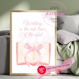 May include: A printable wall art design featuring a pink watercolour illustration of an open book with a pink ribbon and pearl necklace. The text "Writing is the ink trace of the soul." is written in pink lettering.