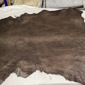 May include: A large piece of brown leather with a wrinkled texture.