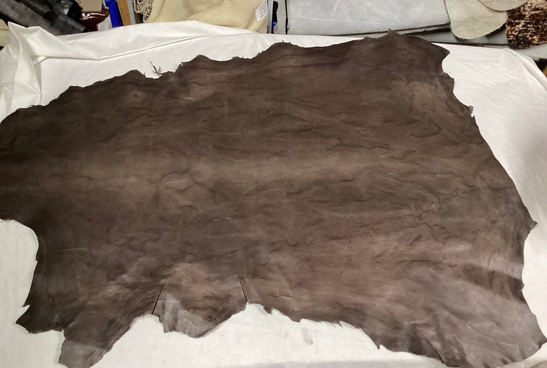 May include: A large piece of brown leather with a wrinkled texture.