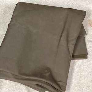 May include: A large piece of brown fabric folded in half. The fabric is smooth and has a slight sheen.