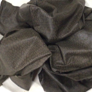 May include: A pile of dark gray fabric with a textured weave.