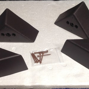 May include: Four dark brown triangular corner braces with screw holes and a bag of screws.