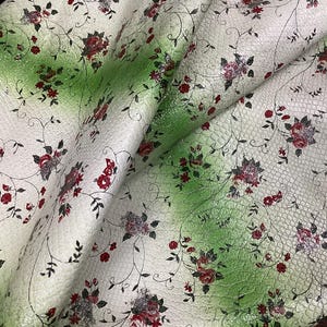 May include: White fabric with a green ombre effect and a floral pattern. The fabric has a textured, snakeskin-like surface.