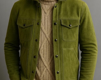 Puede incluir: Chaqueta de ante verde oliva con cuatro bolsillos delanteros y cierres de botón. La chaqueta se lleva sobre un jersey de cuello alto beige de punto trenzado. El modelo también lleva pantalones marrones. Un conjunto elegante para el otoño.