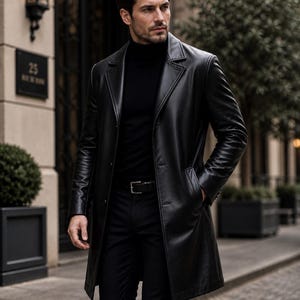 May include: A black leather coat with a classic design. The coat features a notched collar, button closure, and a belt. The model is wearing a black turtleneck and black pants. The coat is knee-length and has a sleek, polished appearance.