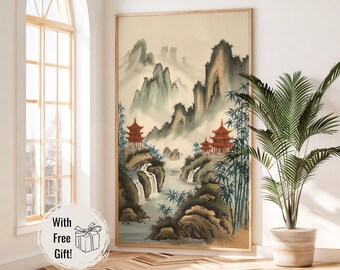 Könnte beinhalten: Ein Aquarellbild einer traditionellen japanischen Landschaft mit Bergen, einem Fluss, Wasserfällen und roten Pagoden. Das Bild ist in einem hellen Holzrahmen gerahmt und hängt an einer weißen Wand.