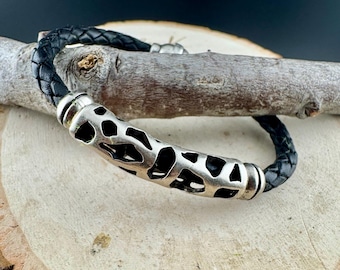 Pulsera de cuero trenzado con cierre deslizante plateado y cierre magnético.