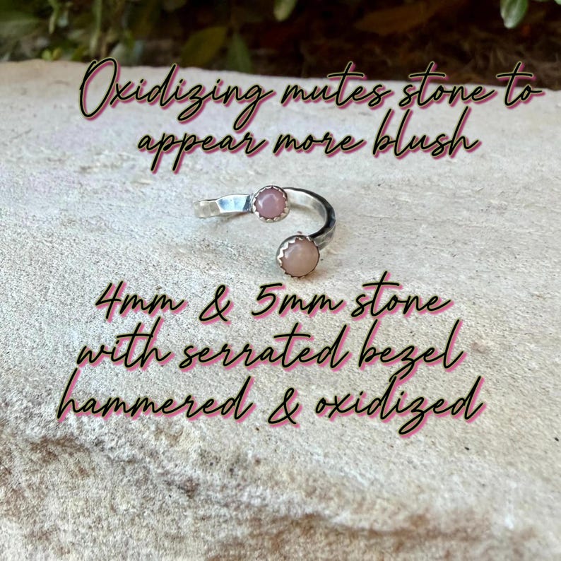 May include: A silver open ring featuring two round blush-colored stones, one 4mm and one 5mm, set in serrated bezels. The band has a hammered and oxidized finish. Text on image: Oxidizing mutes stone to appear more blush. 4mm & 5mm stone with serrated bezel hammered & oxidized.
