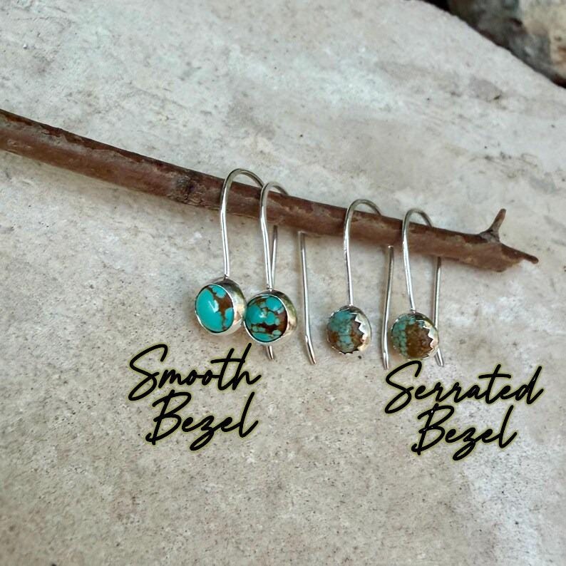 May include: Two pairs of silver hook earrings featuring round turquoise stones with brown matrix. The left pair has a smooth bezel setting labeled Smooth Bezel, and the right pair has a serrated bezel setting labeled Serrated Bezel.