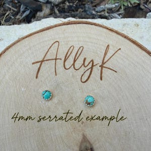 May include: Two small, round turquoise earrings with a serrated silver edge are displayed on a wooden surface. The earrings are labeled as 4mm. The word "Allyk" is written in cursive on the wood.