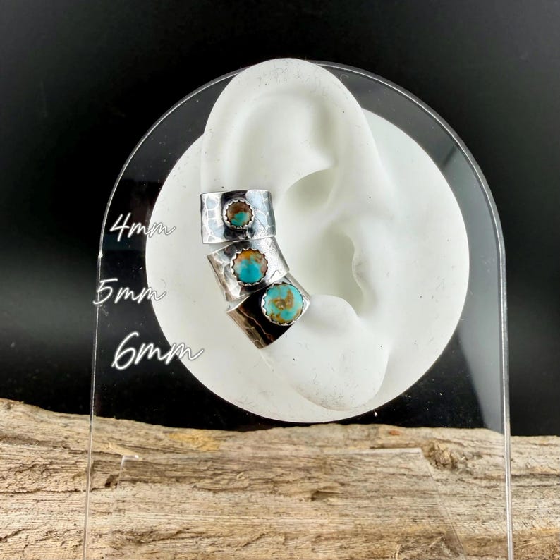 May include: Three silver-tone ear cuffs with turquoise stones are displayed on a white ear model. The cuffs are textured and have a hammered metal appearance. Measurements of 4mm, 5mm, and 6mm are visible on the clear display.