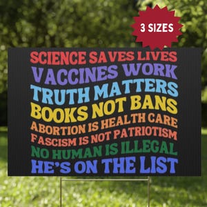 Op de afbeelding: Zwart tuinbord met kleurrijke tekst: "WETENSCHAP REDT LEVENS, VACCINS WERKEN, WAARHEID DOET ERTOE, BOEKEN NIET VERBODEN, ABORTUS IS GEZONDHEIDSZORG, FASCISME IS GEEN PATRIOTISME, GEEN MENS IS ILLEGAAL, HIJ STAAT OP DE LIJST." Rode ster voor 3 maten.