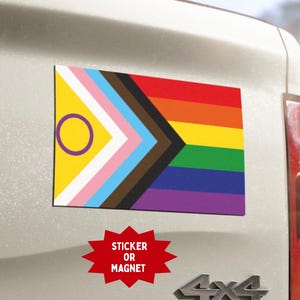 May include: A white ceramic mug with a black handle and the text "But First, Coffee" in a bold, black font. The mug is set against a blurred background, suggesting a cozy setting.