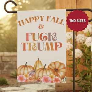 May include: A garden flag with the text "HAPPY FALL & FUCK TRUMP" in orange, pink, and brown lettering. The flag features watercolor pumpkins and flowers at the bottom. A red tag indicates "TWO SIZES".