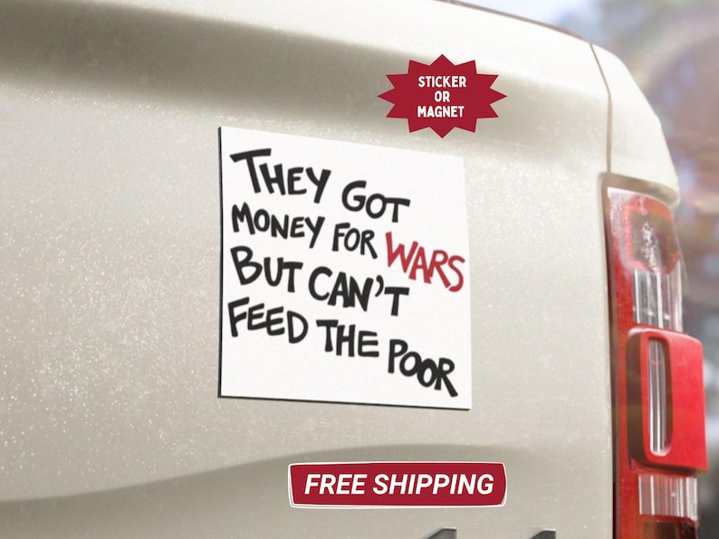 May include: A white square sticker or magnet with the text "THEY GOT MONEY FOR WARS BUT CAN'T FEED THE POOR" in black and red. The sticker is affixed to a vehicle.