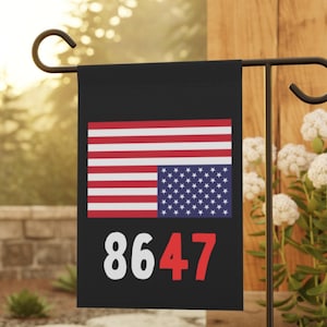 May include: A rectangular black garden flag featuring a graphic of the United States flag with horizontal red and white stripes and a blue field with white stars. Below the flag graphic, the number 8647 is printed in white and red text.