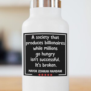 May include: White water bottle with a silver lid. A black rectangle with white text reads "A society that produces billionaires while millions go hungry isn't successful. It's broken. MAYOR ZOHRAN MAMDANI" with five red stars.