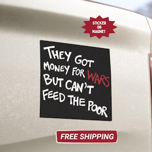 May include: Black square sticker or magnet with white text reading "THEY GOT MONEY FOR WARS BUT CAN'T FEED THE POOR." The word "WARS" is in red. The sticker is affixed to a white vehicle.
