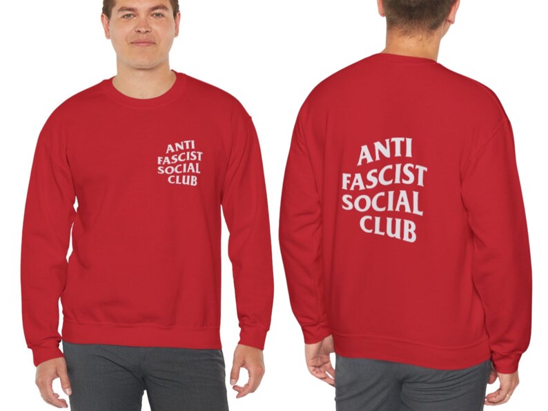 K&ouml;nnte beinhalten: Rotes Sweatshirt mit dem wei&szlig;en Text "ANTI FASCIST SOCIAL CLUB" auf der Vorder- und R&uuml;ckseite. Das Sweatshirt ist ein Rundhals-Stil und scheint aus einem weichen Material zu sein.