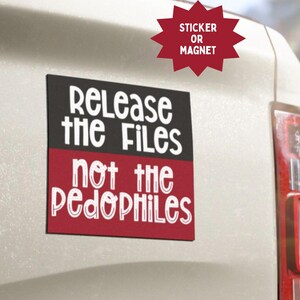 Puede incluir: Una pegatina o imán rectangular con el texto "Release the Files not the Pedophiles" en fuente blanca sobre un fondo negro y rojo. La pegatina está adherida a la parte trasera de un vehículo blanco.