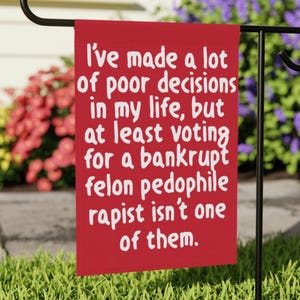 May include: A red garden flag with white text that reads: "I've made a lot of poor decisions in my life, but at least voting for a bankrupt felon pedophile rapist isn't one of them."