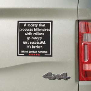 May include: A black bumper sticker with white text that reads "A society that produces billionaires while millions go hungry isn't successful. It's broken." The sticker also includes the name "Mayor Zohran Mamdani" and a 5-star rating.
