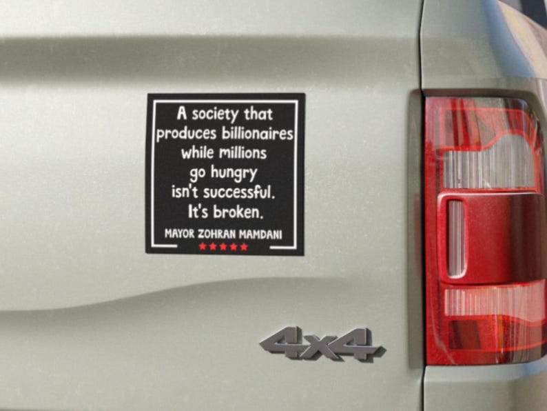 May include: A black bumper sticker with white text that reads "A society that produces billionaires while millions go hungry isn't successful. It's broken." The sticker also includes the name "Mayor Zohran Mamdani" and a 5-star rating.